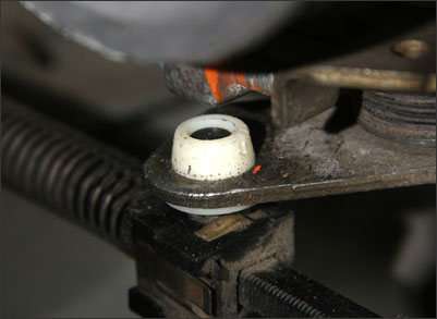 A pin on the throttle valve rod fits through a hole in a metal bracket attached to the throttle cable